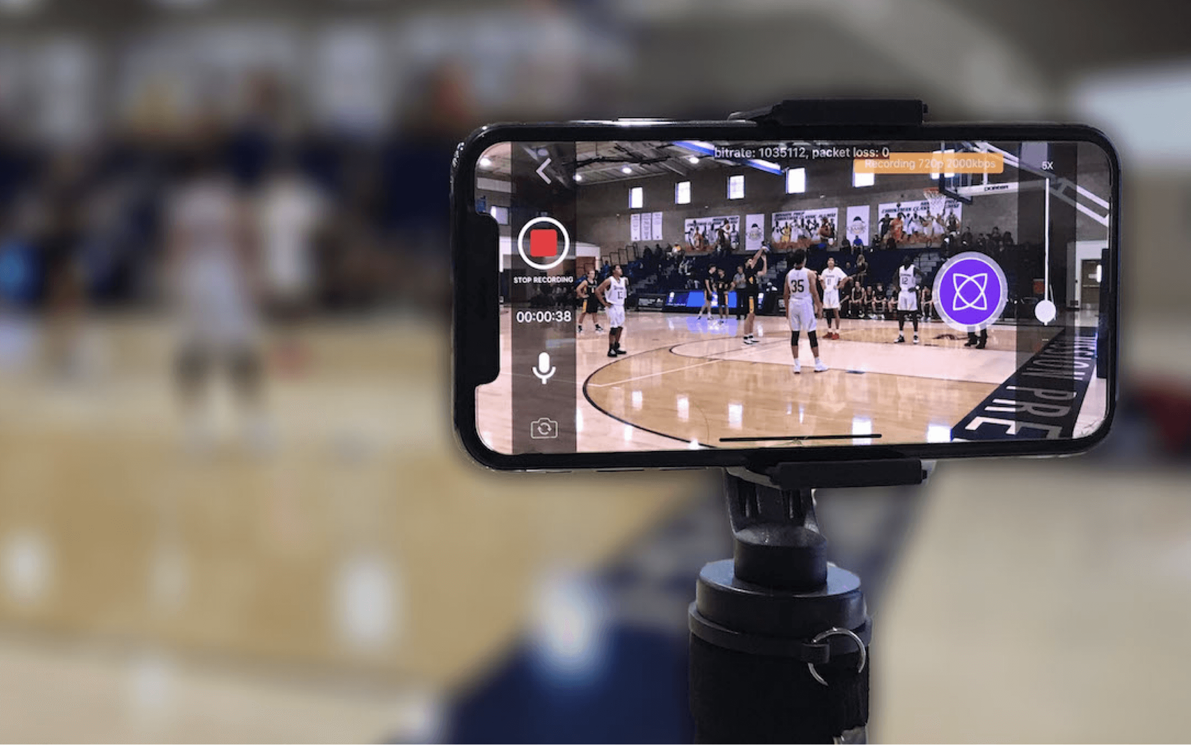 A phone attached to a tripod, recording a live basketball game with the fantag app.