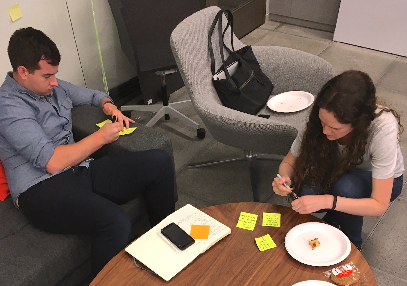 Design workshop participants writing on sticky notes